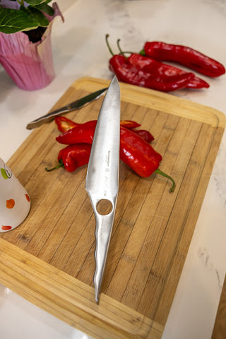 Close-up of the sharp blade of the Season and Stir™ Achilles Chef's Knife by Sternsteiger highlighting its high-quality stainless steel material.