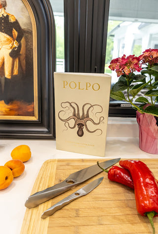 A beautifully arranged kitchen scene featuring the Season and Stir™ Achilles Chef's Knife by Sternsteiger alongside fresh herbs and ingredients.