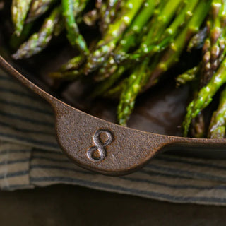 Lancaster Cast Iron Skillet Number 8 elegantly arranged with culinary herbs and spices, perfect for any cooking enthusiast.